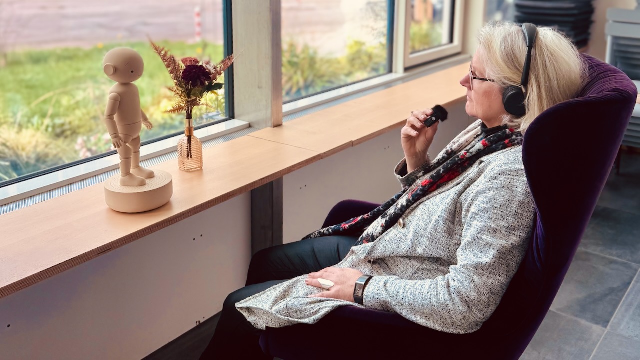 Seniorin spricht mit Haruto über ein Headset in einer Pflegeeinrichtung