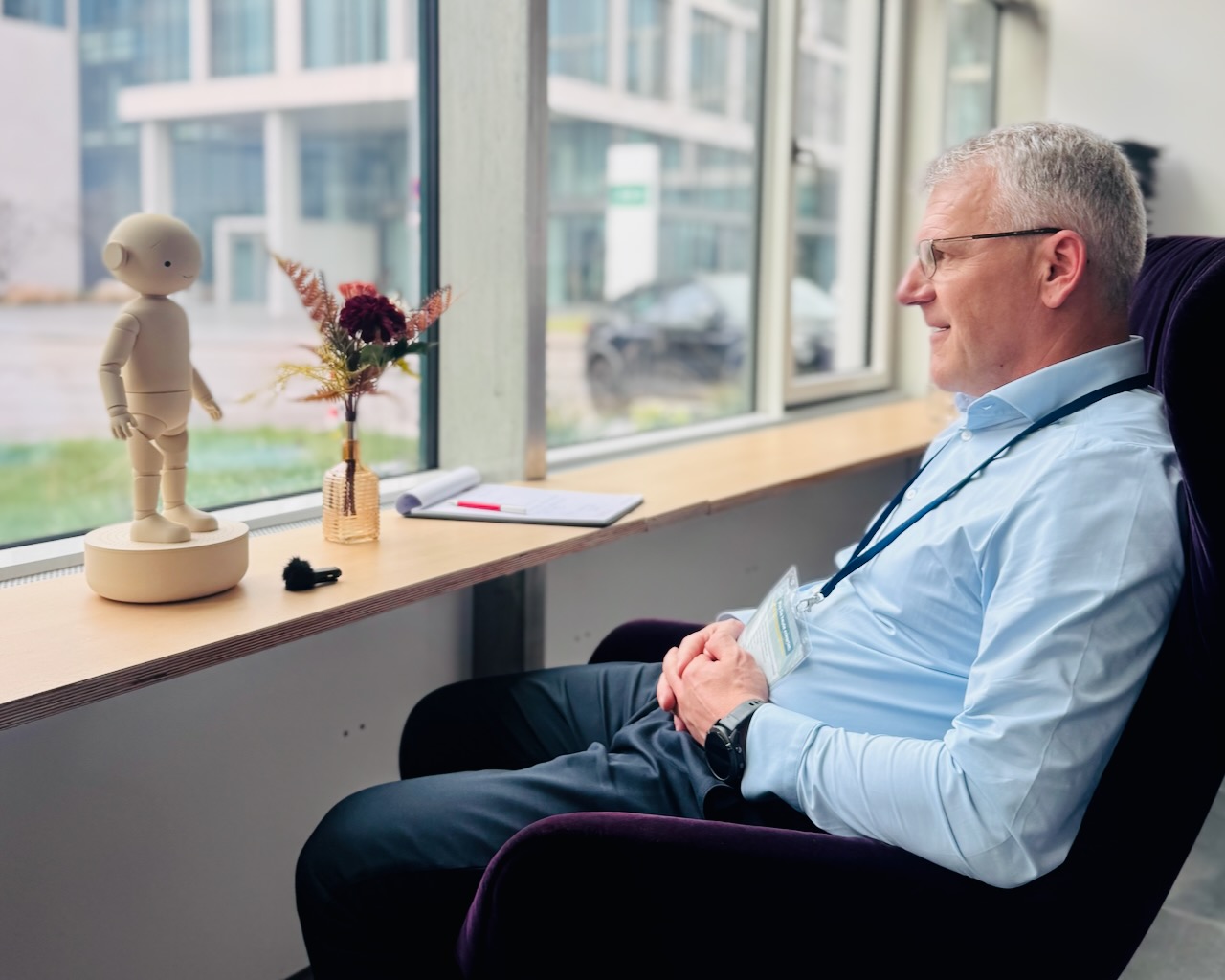 Mann im Gespräch mit dem Haruto Begleiter am Fenster
